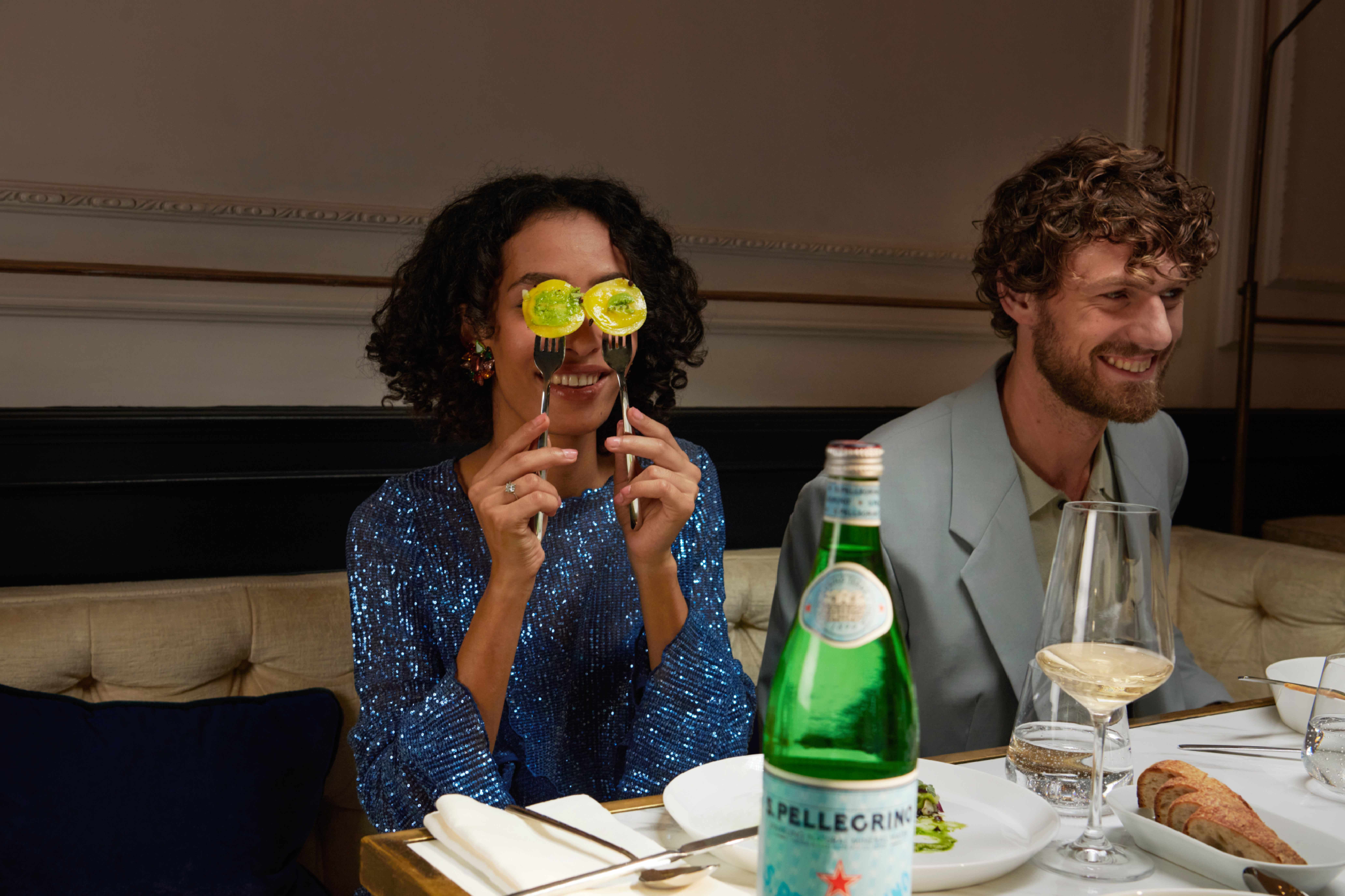 Des amis dînent au restaurant avec S.Pellegrino.