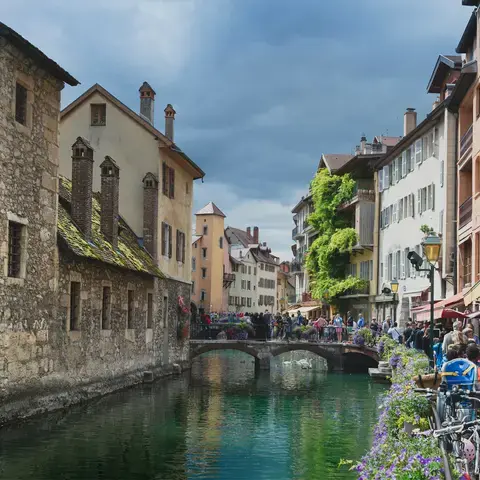 Vieille ville d’Annecy, canal bordé de fleurs et ruelles pavées animées, entre architecture médiévale et cafés pittoresques.