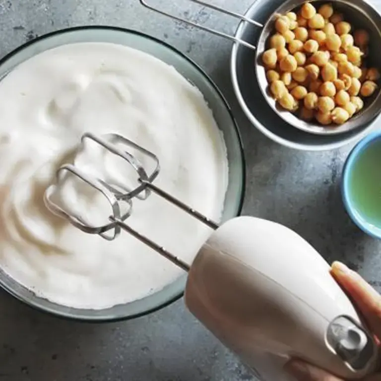 pois chiches dans une petite passoire et aquafaba montée en neige avec un batteur
