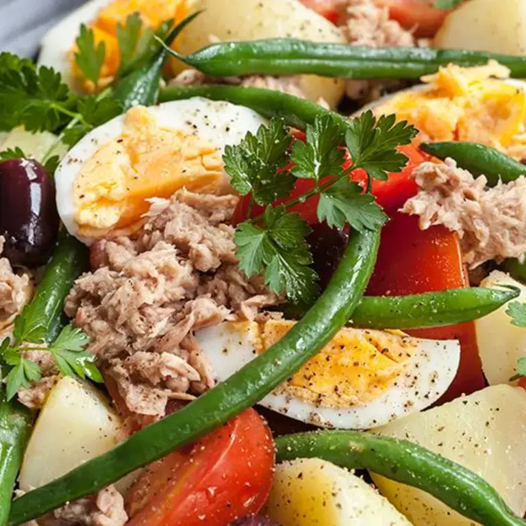 salade avec des tomates, des œufs durs, du ton, des haricots verts, des pommes de terre et de olives