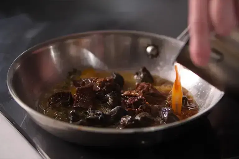 Ajouter les joues de bœuf et un peu de jus de braisage