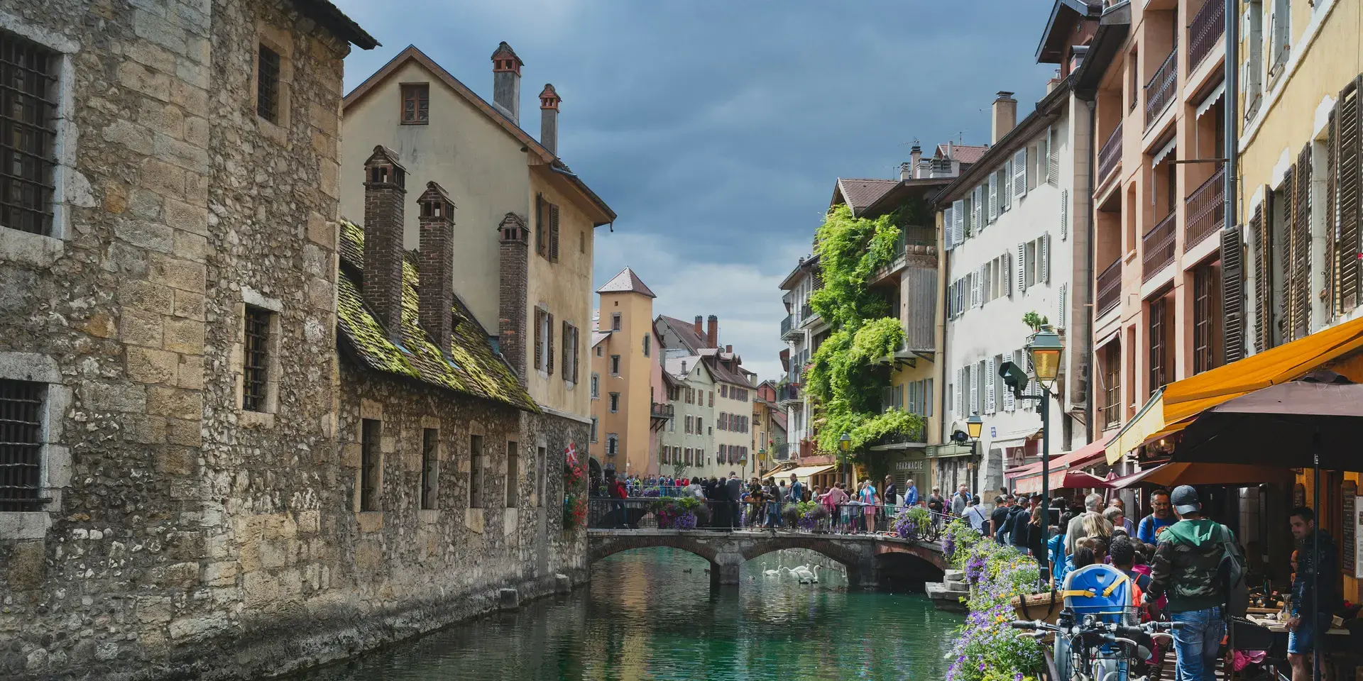 Vieille ville d’Annecy, canal bordé de fleurs et ruelles pavées animées, entre architecture médiévale et cafés pittoresques.