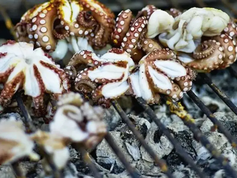 poulpe qui cuit sur une grille de barbecue